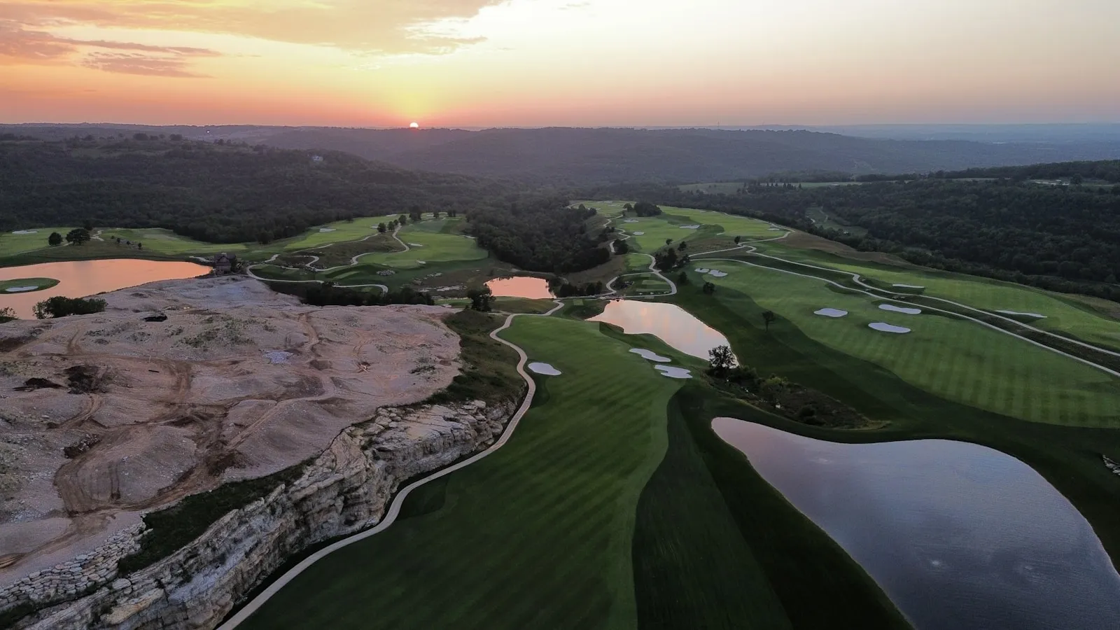 Golden-hour aerial of a north-woods golf hole